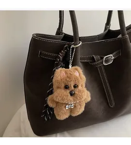 Dettaglio del ciondolo a forma di cane di peluche marrone con perle e medaglietta