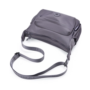 Close-up of dark grey waterproof nylon bag featuring multiple zippers and adjustable strap
