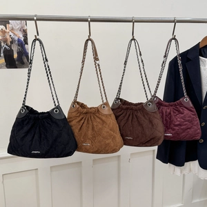 Close-up of quilted bucket bags in black, camel, brown and burgundy with chain straps