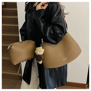 Brown faux leather shoulder bag set with stylish teddy bear charm on model shoulder