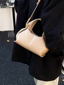 Beige pleated cloud dumpling bag in pebbled leather with a slender shoulder strap