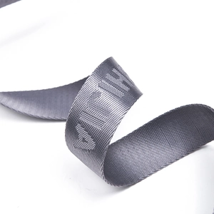 Macro detail of grey woven jacquard strap with embossed OFF lettering for crossbody bag