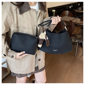 Detail of black pebbled leather tote and pouch set featuring Fashion & Bag lettering