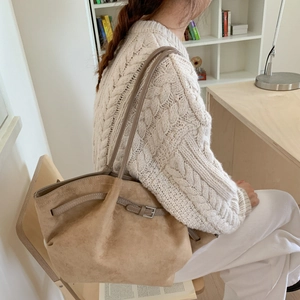 Detail einer khakifarbenen Wildleder-Shopper mit grauem Schultergurt in Wohnambiente