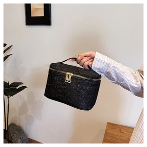 Dettaglio della borsa trucco nera glitterata con doppia cerniera dorata e manico
