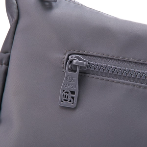 Close-up of grey waterproof nylon material with detailed zipper and MSSJ logo engraving