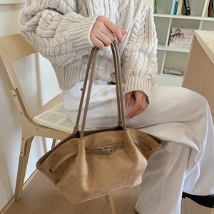 Detailansicht der braunen Wildledertasche mit Metallschnalle und eleganter Faltenoptik