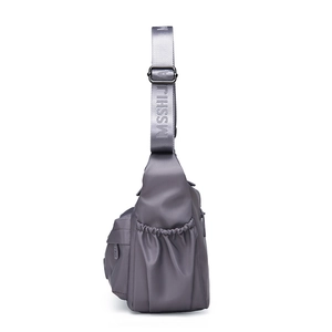 Detail view of water-resistant nylon bag featuring a side drawstring pocket and logo strap