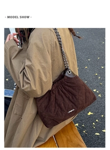 Close-up of brown quilted bucket bag with silver chain strap and autumn outdoor detail