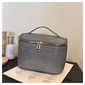 Dettaglio della trousse trucco glitter argento con doppia zip in metallo e manico superiore