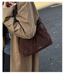 Close-up of brown quilted bucket bag with chain strap and silver JINGPIN metal logo