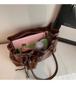 Detail showing spacious interior of brown tote bag with tablet and daily essentials