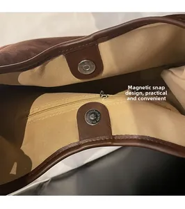 Detail view of suede tote bag interior with magnetic snap closure and zipper pocket