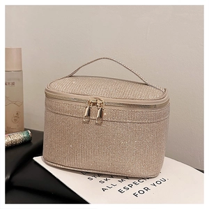 Dettaglio della borsa trucco glitter oro champagne con manico e doppia cerniera dorata