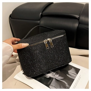 Dettaglio beauty case nero glitterato con doppia cerniera dorata e pratico manico superiore