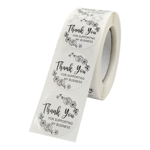 Roll of round white business thank you stickers with black floral border and elegant text