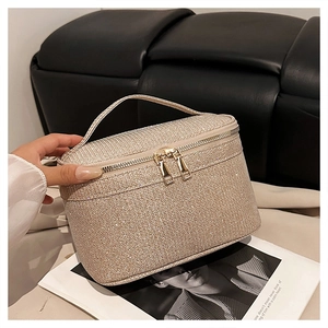 Dettaglio del beauty case glitterato oro champagne con doppia cerniera dorata