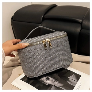 Dettaglio della borsa da trucco glitter argento con doppia cerniera dorata e manico