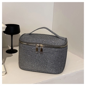 Dettaglio della borsa cosmetica glitter argento con doppie cerniere dorate e maniglia