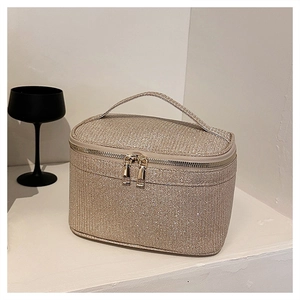 Dettaglio della grande borsa cosmetica in paillettes champagne con cerniere dorate