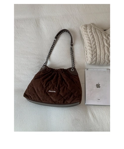 Detail view of quilted brown chain bag featuring soft velvet texture and metal logo
