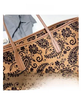 Close-up of bohemian paisley pattern and premium leather stitching on the brown tote bag