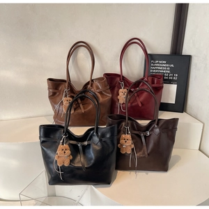Detailed display of four vintage tote bags with bear charms in various earthy tones