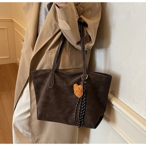 Détail du grand sac cabas marron mat avec breloque ours et ruban rayé décoratif
