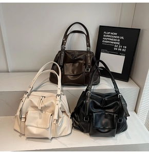 Three oversized faux leather tote bags in cream, brown, and black colors on marble steps