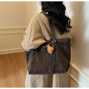 Détail du grand sac cabas marron avec charm ours en peluche et surpiqûres blanches