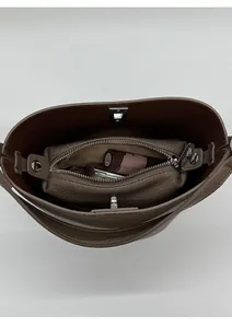 Gros plan d'un sac seau taupe montrant l'intérieur spacieux et la pochette zippée