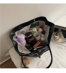 Internal view of black tote bag showing large capacity storage and striped lining