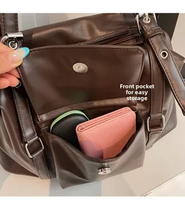 Detail view of large front flap pocket on a dark brown leather tote for easy storage