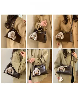 Detail view of retro brown bucket bag with plush bunny charm paired with a camel coat