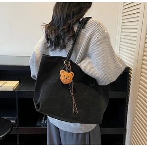 Détail du grand sac cabas noir avec coutures blanches contrastées et charm ourson en peluche