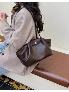 Détail d'un grand sac cabas en cuir froissé marron foncé avec boucle dorée et bandoulière