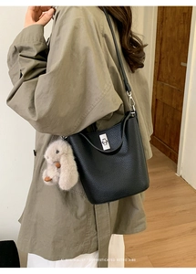 Détail du sac seau en cuir grainé noir avec fermoir rotatif argenté et bijou lapin