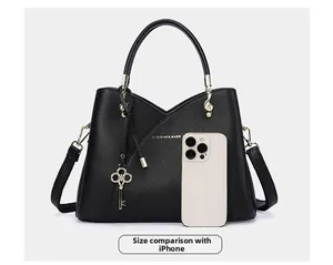 Black pebbled leather bucket bag size comparison with an iPhone featuring gold hardware