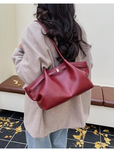 Détail du sac bandoulière rouge vin avec boucle dorée et manteau d'hiver chaud