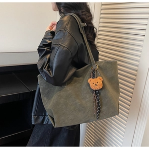 Détail du grand sac cabas mat vert olive avec pendentif ours porté par un mannequin
