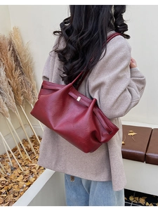 Détail du sac cabas en cuir bordeaux à texture souple et boucle en métal pour la mode d'automne