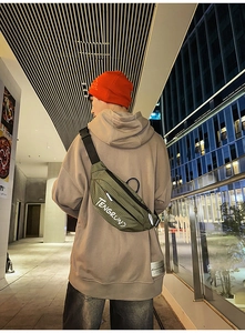 Buitenaanzicht van de olijfgroene crossbodytas met netstructuur en reflecterende strips