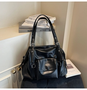 Detailed close-up of black retro tote bag featuring silver metal rivets and hardware