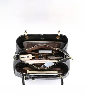 Top view showing three-compartment interior storage of black leather handbag with tablet