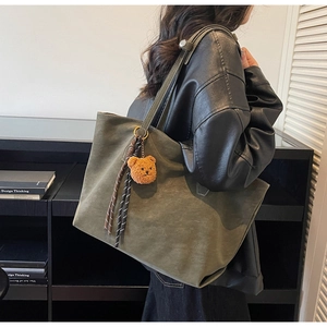 Détail du grand sac cabas vert olive mat avec pendentif ours sur un mannequin femme