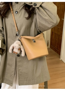 Détail du sac seau kaki avec texture litchi et pendentif de lapin en peluche