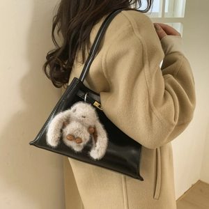 Retro black crossbody bucket bag with a cute white plush bunny charm on a model