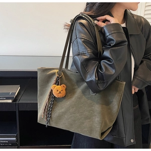 Détail du grand sac cabas vert olive avec breloque ours en peluche et surpiqûres