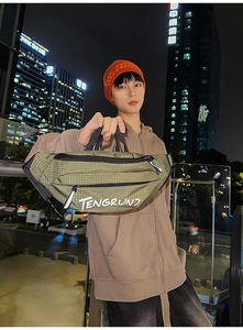 Detailopname van de groene geblokte crossbodytas met TENGRUN-logo en verstelbare nylon riem