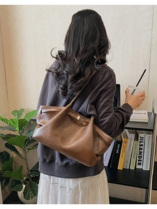 Détail d'un grand sac cabas en cuir marron souple avec un fermoir en métal doré élégant